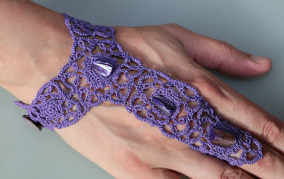 Handschmuck aus Baumwollgarn in lila mit Perlmuttsteinen, Knopfverschluß